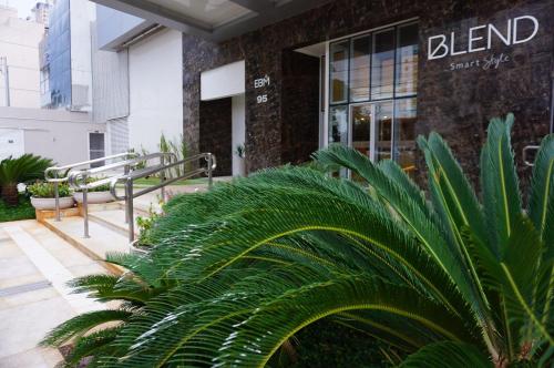 una palmera frente a un edificio en Blend Smart Style Estúdios Luxuosos e Decorados, en Goiânia