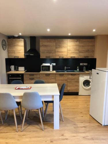 une cuisine avec une table et des chaises et un réfrigérateur blanc dans l'établissement Gîte la Diva, à Lagrave