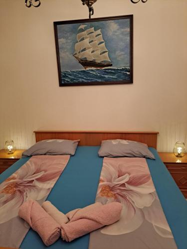 een slaapkamer met twee bedden en een boot aan de muur bij Apartman PIK in Karlobag