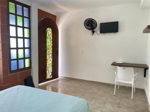 um quarto com uma cama, uma secretária e um vitral. em Casa hotel Mateguadua em Apartadó