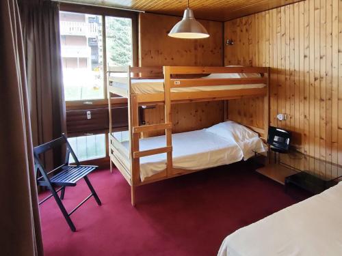 Cette chambre comprend 2 lits superposés et une chaise. dans l'établissement Appartement La Clusaz, 2 pièces, 4 personnes - FR-1-459-198, à La Clusaz