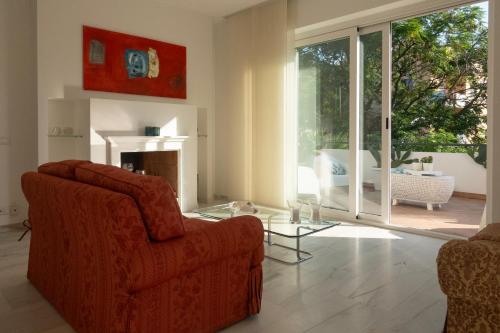 een woonkamer met een rode stoel en een glazen tafel bij Civico89 in Pescara