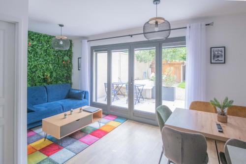 ein Wohnzimmer mit einem blauen Sofa und einem Tisch in der Unterkunft Le Saint-Germain - Porte d'Orléans - Cité Universitaire Paris 14 in Gentilly