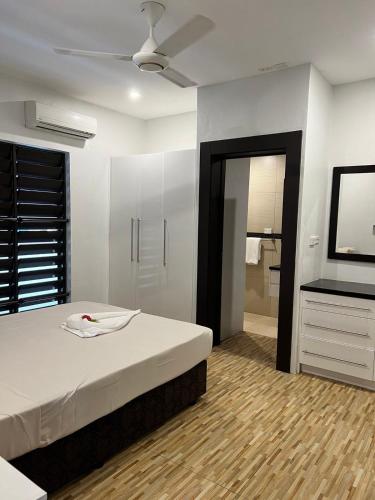 a bedroom with a bed and a flat screen tv at Garden Apartments in Nadi