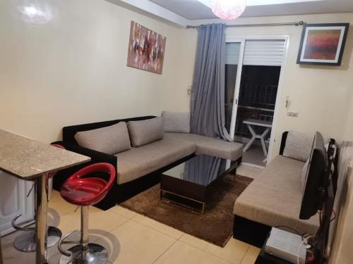 Booking house في أغادير: غرفة معيشة مع أريكة وطاولة
