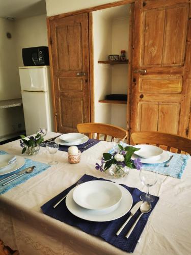 einen Tisch mit weißen Tellern und Küchenutensilien darauf in der Unterkunft Gîte du pont tournant in Torcy