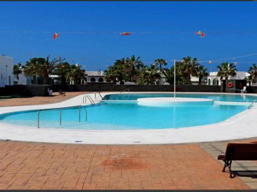 ein großer Pool mit blauem Wasser und Palmen in der Unterkunft Villa Karisa in Playa Blanca