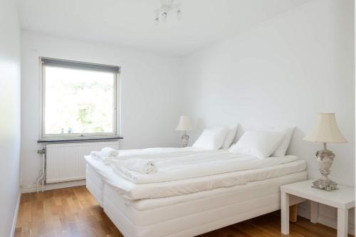 ヨーテボリにあるWHITE & BRIGHT Room in a shared apartmentの窓付きの白い部屋の白いベッド