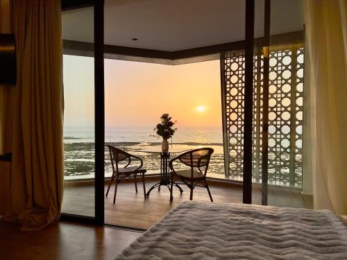 a bedroom with a bed and a view of the ocean at Les Roches De Mazagan in El Jadida