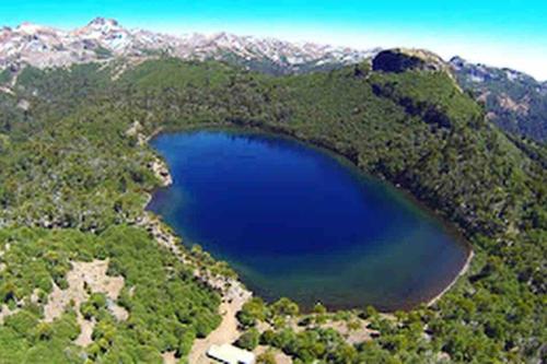 an aerial view of a blue lake in the mountains at Sor Vicenta Suites in San Carlos de Purén