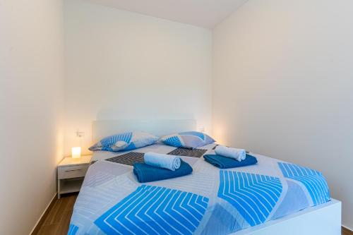 1 dormitorio con 1 cama grande con almohadas azules en New 4 star Room M&A in town Cres en Cres
