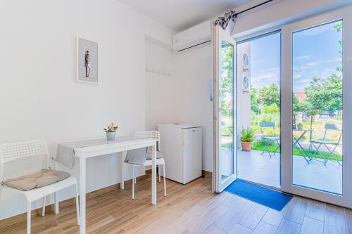 um quarto branco com uma secretária e uma porta de vidro deslizante em New 4 star Room M&A in town Cres em Cres