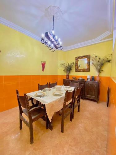 a dining room with a table and chairs and a mirror at Dar Baddi in Marrakech