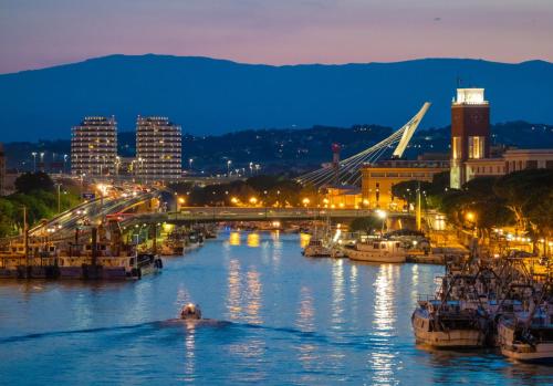 a river with boats docked in a city at night at Civico89 in Pescara