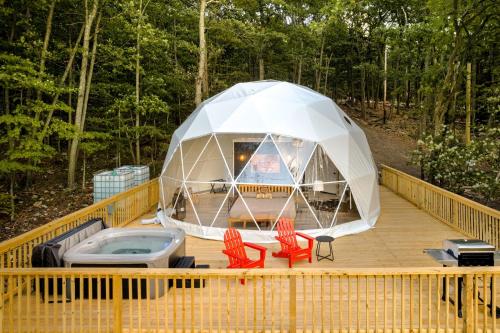 an iguana tent on a deck with two chairs at Luxe Dome w Hot Tub, Full Bath & Mountain View in Augusta