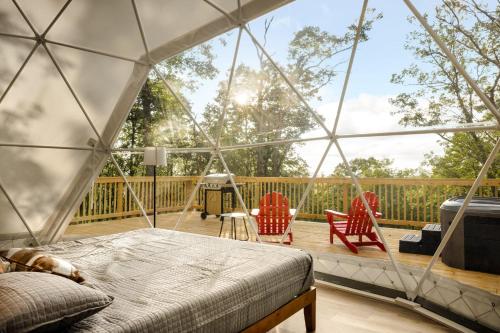 a tent with a bed and two chairs on a deck at Luxe Dome w Hot Tub, Full Bath & Mountain View in Augusta