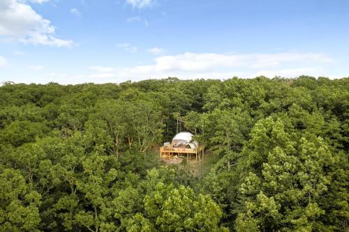 an aerial view of a dome house in the woods at Luxe Dome w Hot Tub, Full Bath & Mountain View in Augusta