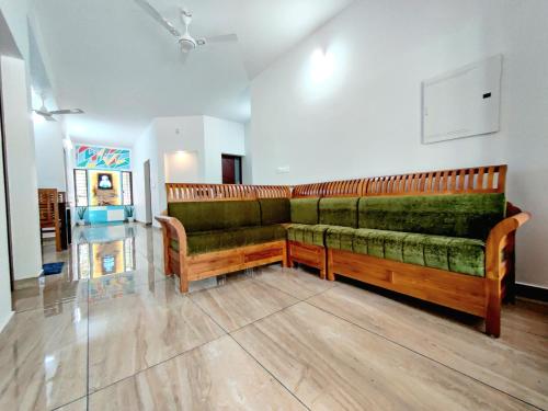 a living room with a green couch in a room at Abode Homestay Alleppey Near Omanapuzha Beach in Alleppey