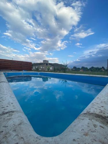 una gran piscina azul bajo un cielo nublado en ALOHA, en Sierra de la Ventana