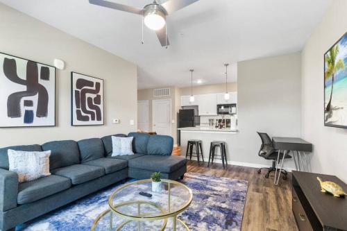 a living room with a blue couch and a table at Luxe 1BR/1BA: Dive, Rest, Explore. Book Now! in Melbourne