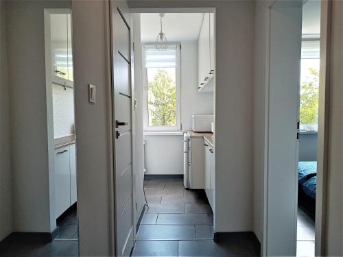 a small kitchen with a hallway with a window at Kryształowy apartament in Tarnowskie Góry