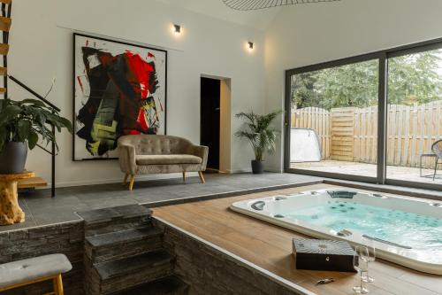 a living room with a jacuzzi tub and a chair at Wellness Loft Huy in Huy