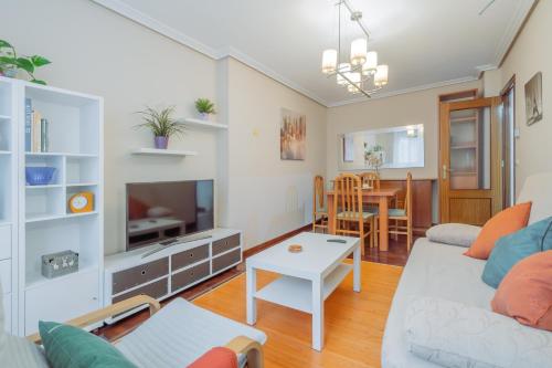 sala de estar con sofá y mesa en Luminoso y acogedor apartamento con wifi, en Gijón