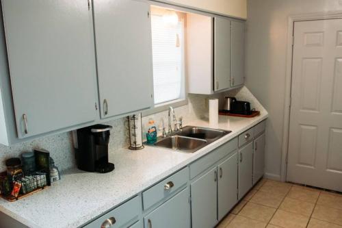 a kitchen with white cabinets and a sink at Bronze Star on Fairway in Longview