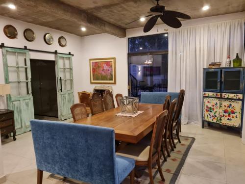 a dining room with a wooden table and blue chairs at La Pinta Hotel Boutique in San Bernardino