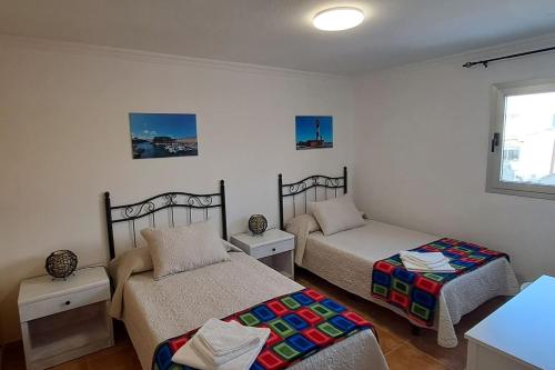 a bedroom with two beds and a window at Casa Abuelo Antonio in El Cotillo