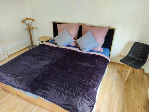 ein Schlafzimmer mit einem großen Bett mit blauen und rosa Kissen in der Unterkunft Ferienwohnung Obere Aue in Niederau
