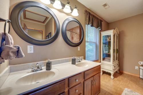 a bathroom with two sinks and two mirrors on the wall at Hot Tub and Fire Pit! Lake-View Home in Blue Eye in Blue Eye