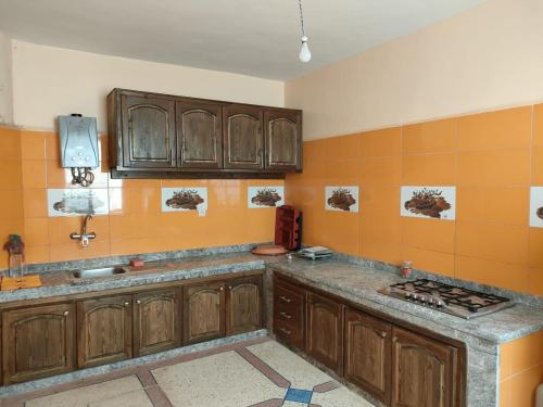 - une cuisine avec des placards en bois et un comptoir dans l'établissement Belles appartements à côté de la plage Tamehrouchte, à Mirleft
