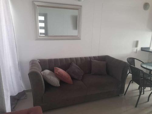 a living room with a brown couch and a mirror at CASA AMOBLADA EN CONJUNTO CERRADO in Cúcuta
