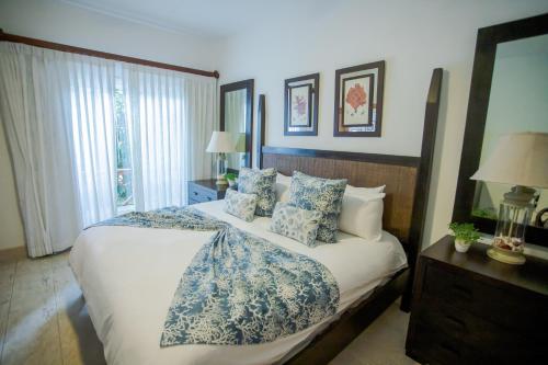a bedroom with a large bed with blue and white pillows at Xeliter Balcones del Atlantico - Las Terrenas in Las Terrenas