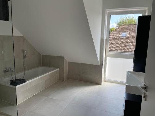 a bathroom with a bath tub and a window at Heide-Liebe in Soltau