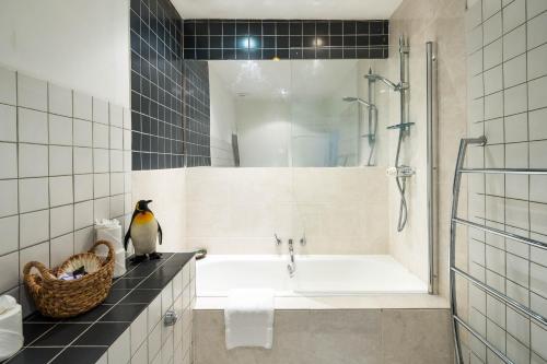 a bathroom with a penguin sitting on a counter next to a tub at Elegant and Peaceful 2BD apt - Barons Court/London in London