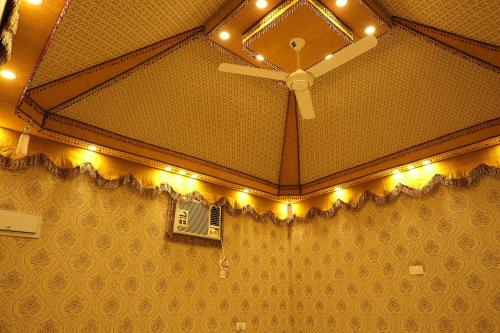 a ceiling with a fan and a window with lights at Salem Fish Guest House in Al Ḩadd