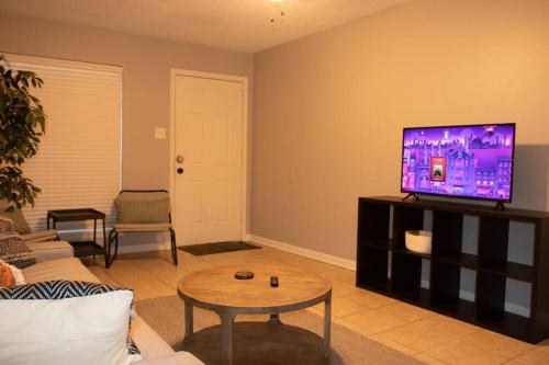 a living room with a flat screen tv on a cabinet at Hidden Treasure in Longview