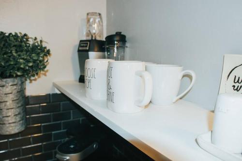 a row of white cups sitting on a counter at Hidden Treasure in Longview
