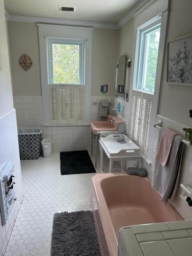 a bathroom with a pink tub and a sink at Enloe House in Roanoke