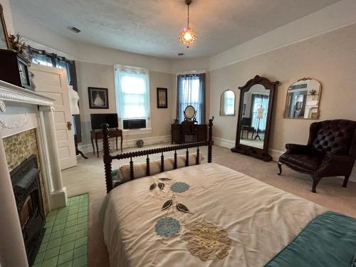 a bedroom with a bed and a fireplace and a mirror at Enloe House in Roanoke