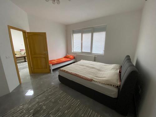 Schlafzimmer mit einem Bett, einem Fenster und einer Tür in der Unterkunft Saray in Sarajevo