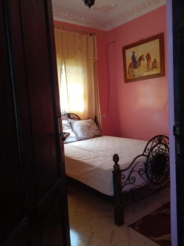 een slaapkamer met een bed in een roze kamer bij Ourika in Ourika