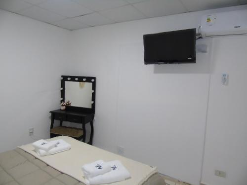 a room with a bed and a mirror and a tv at H2O CENTRO in Federación