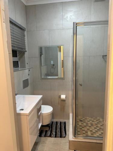 y baño con ducha, aseo y lavamanos. en Canal View Estate & Resort en Manzini