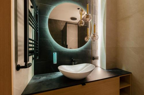 a bathroom with a white sink and a mirror at SKY Home- Wood Penthouse -Manufaktura, Parking, Klimatyzacja, Dostęp na Kod in Łódź