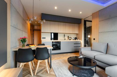 a living room with a couch and a table at SKY Home- Wood Penthouse -Manufaktura, Parking, Klimatyzacja, Dostęp na Kod in Łódź