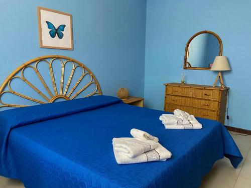 a blue bedroom with towels on a blue bed at Villa Vinci in Menfi