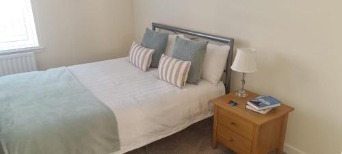 a bedroom with a bed with pillows and a table at 2 bed city centre executive apartment in Aberdeen